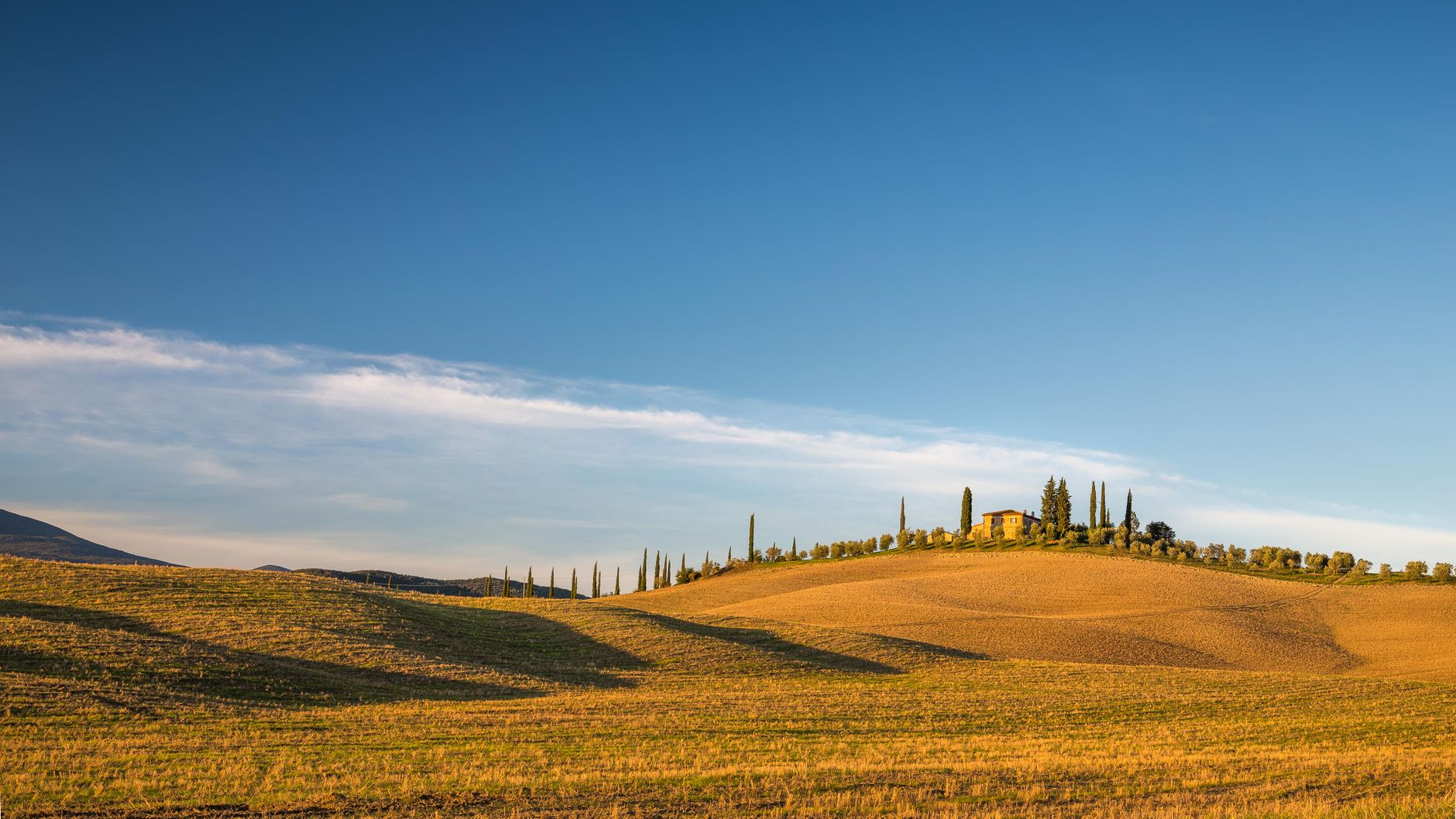 Sun setting over gentle Tuscan rolling hills